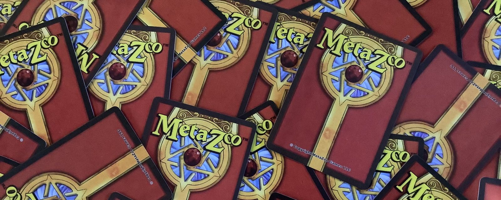 Photo showing the backs of scattered MetaZoo cards.